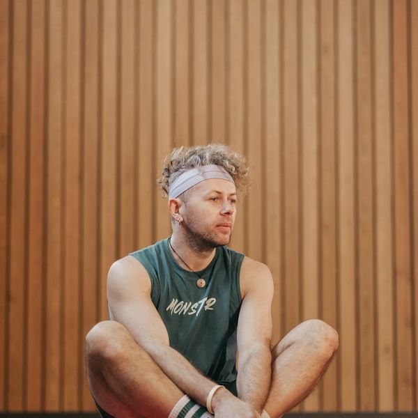 Man sitting in a calm, meditative pose after an exercise routine.